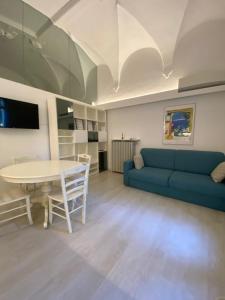 代森扎诺-德尔加达DUOMO26 BOUTIQUE APARTMENT的客厅配有蓝色的沙发和桌子