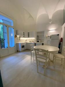 代森扎诺-德尔加达DUOMO26 BOUTIQUE APARTMENT的白色的厨房配有桌椅
