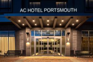 朴茨茅斯AC Hotel by Marriott Portsmouth Downtown/Waterfront的两个长凳的朴茨茅斯酒店大楼入口