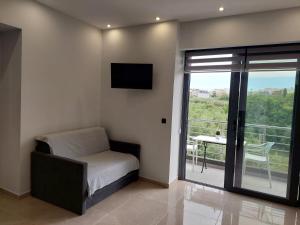 阿默达拉-伊拉克利翁Luana Monte Apartments的一间卧室设有一张床、一台电视和一个阳台。