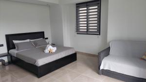 阿默达拉-伊拉克利翁Luana Monte Apartments的一间卧室配有一张床和一把椅子