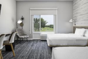 SelmaTownePlace Suites by Marriott San Antonio Universal City, Live Oak的酒店客房带两张床、椅子和窗户