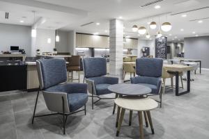 SelmaTownePlace Suites by Marriott San Antonio Universal City, Live Oak的自助餐厅内带蓝色桌椅的等候区