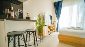 蒂瓦特Royal Blue Resort & Residences的一间卧室设有两张酒吧凳和一张床