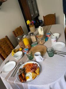 利物浦Room in family home near Penny Lane Liverpool的一张桌子上放着一盘早餐食品