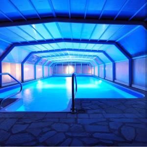弗尔尼亚奇卡矿泉镇Sunny Hill Apartments & Aqua Park的天花板上设有蓝色灯光的游泳池