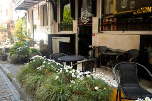 伊斯坦布尔Pearl Hotel İstanbul的餐厅前方的庭院配有桌椅和鲜花