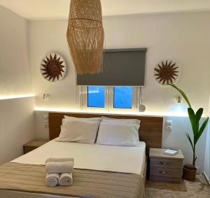 斯基亚索斯镇Del Sol Suites的一间卧室配有一张床和盆栽植物