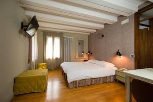 布兰塔河上坎普朗哥Contra' Contarini的酒店客房设有一张大床和一张书桌。