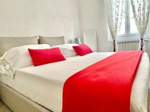 韦尔纳扎Families or Groups 3 Terrazzi Apartment on Sea的一张大白色的床,上面有红色枕头