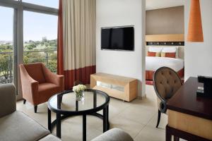 阿克拉Accra Marriott Hotel的配有一张床、一张桌子和一张桌子的酒店客房