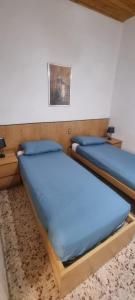 菲利内瓦尔达诺Casa Leonardo & Elisa的配有蓝色床单的客房内的两张床