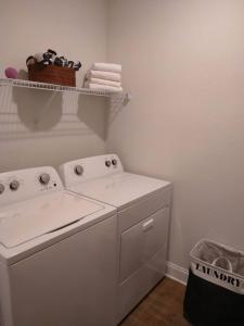 代托纳海滩"OneKey" Luxury Apt - POOL - 4 Mi to Beach的洗衣房内的白色洗衣机,备有篮子