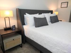 代托纳海滩"OneKey" Luxury Apt - POOL - 4 Mi to Beach的一间卧室配有一张床和一个带床罩的床头柜。