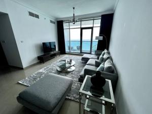 阿吉曼Luxury full sea view flat的客厅配有沙发和桌子