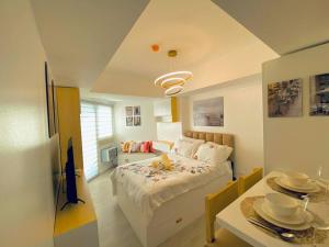 圣费尔南多Sweet Retreat Studio Azure North的一间卧室配有床和一张桌子,上面有盘子