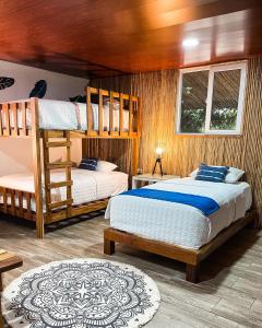 La Herradura太阳海岸托尔图加村酒店的一间卧室设有两张双层床和一扇窗户。