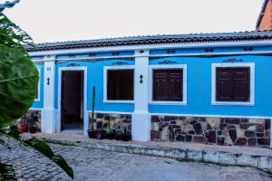 伦索伊斯Buena Vibe Hostel的蓝色的房子,设有两扇窗户和一扇门