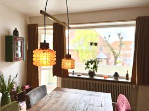 霍森斯2 værelses retro lejlighed på Torvet的餐桌,配有2个吊灯和1个窗户