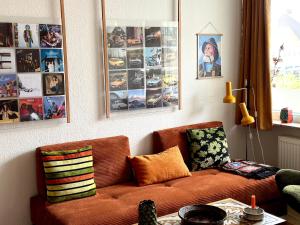 霍森斯2 værelses retro lejlighed på Torvet的客厅配有沙发和墙上的照片