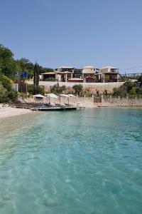 塞沃塔奥尔内拉海滩别墅度假公寓式酒店的一大片水,海滩上摆放着遮阳伞