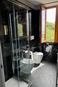 莫内利亚天堂公寓式酒店的一间带玻璃淋浴和卫生间的浴室