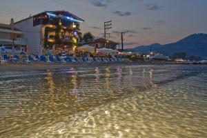 斯卡拉伯塔麦斯Blue Sea Beach Hotel的海滩上晚上设有椅子和酒吧