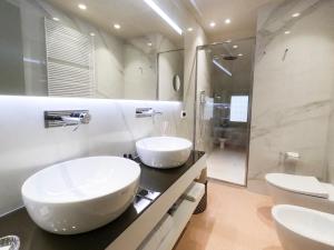 博洛尼亚Palazzo Scappi Gardi Luxury Apartments的一间带两个盥洗盆和淋浴的浴室