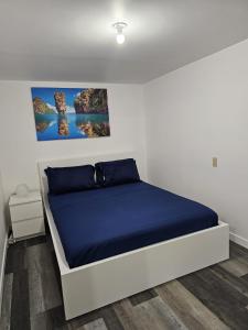 温尼伯River Park South - 2 Bedroom Basement Suite的一间卧室配有一张带蓝色床罩的床