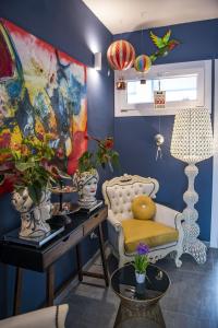 费拉拉Boutique Hotel Ferrara的蓝色的房间,配有椅子和鲜花桌