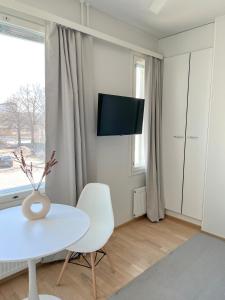 奥卢Studio Apartment Station的白色的客厅配有白色桌子和电视。