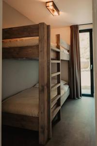ChaamLuxe schuurwoning 't Nieuwt in Chaam, Nederland的一间卧室设有两张双层床和一扇窗户。