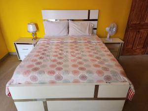 Super Two Bedroom Penthouse in Peguy-Ville的一间卧室配有一张带粉红色鲜花的大床