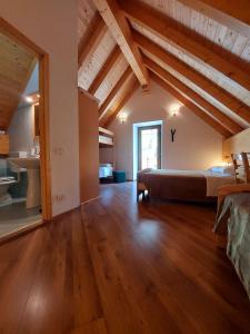 托尔梅佐Rifugio Fornas的一间带一张床的卧室,位于带木制天花板的房间内