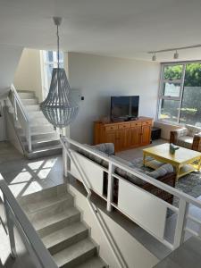 普利登堡湾Sunset Cove的客厅设有楼梯、电视和桌子
