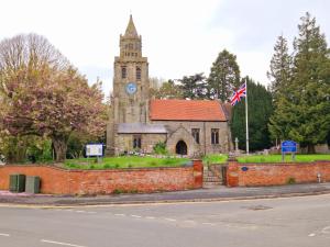 PlumtreeBunny Lodge - Garden view & free parking的一座古老的教堂,有钟楼,有旗帜