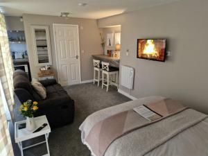 PlumtreeBunny Lodge - Garden view & free parking的客厅配有沙发和墙上的电视