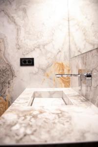 蒂米什瓦拉Cosmopolita Boutique Hotel的白色大理石浴室设有水槽