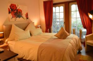 巴德贝芬森Landhaus Zum Heidewanderer的卧室配有一张带红色窗帘的大型白色床