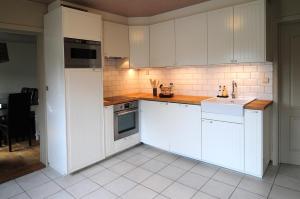托尔豪特Holiday home De Levensgenieter的厨房配有白色橱柜和水槽