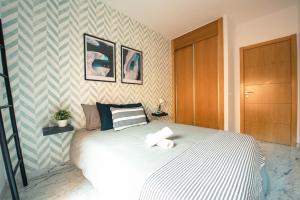 贝莱斯Nordik Rooms Village - Chilches "Taby"的一间卧室配有一张床,上面有两条毛巾