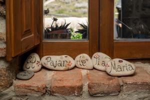Casas del CastañarEl Pajar de Tía María的四个石头,上面写着,坐在窗前