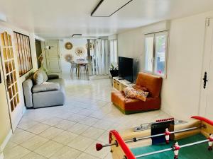 Boissy-lʼAillerieAppartement 120m2 dans maison avec piscine的客厅配有家具和电视。