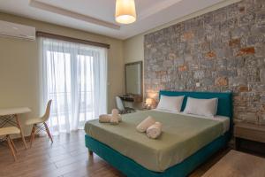 卡拉马塔Verga's Apartments的一间卧室设有一张大床和砖墙