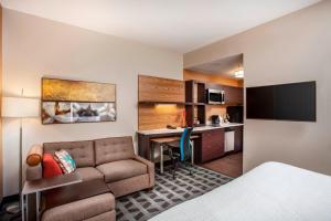 奥兰多TownePlace Suites by Marriott Orlando Altamonte Springs/Maitland的带沙发和书桌的酒店客房