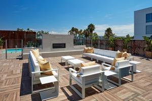 唐尼SpringHill Suites by Marriott Los Angeles Downey的天井配有沙发、椅子和壁炉
