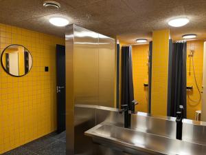 卑尔根City Hostel Bergen的浴室设有2个水槽、镜子和黄色瓷砖