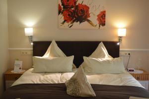 巴德贝芬森Landhaus Zum Heidewanderer的一间卧室配有白色床单和红色鲜花。