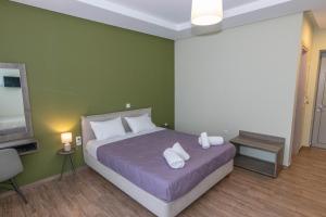 卡拉马塔Verga's Apartments的一间卧室配有带两个枕头的床和电视
