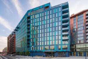 华盛顿AC Hotel by Marriott Washington DC Capitol Hill Navy Yard的街上的蓝色建筑,设有玻璃窗